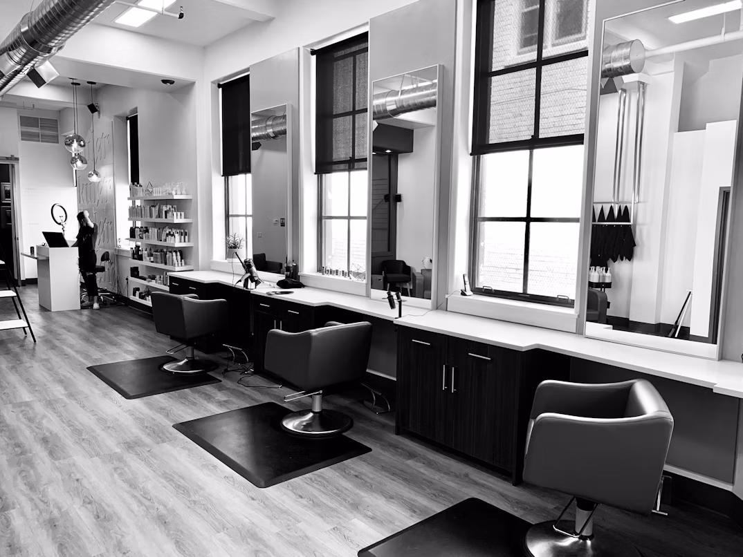 Luxurious salon interior with black styling chairs, mirrors, and warm salon lighting